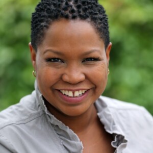 Aimee is a Black woman wearing a gray shirt.