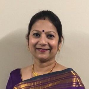 Chandreyee is a South Asian woman who is wearing a red dress.