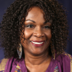 Danielle is a black woman wearing a purple shirt.
