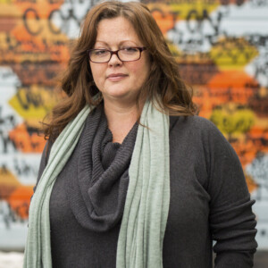Desdamona is a white female wearing a gray shirt and glasses.