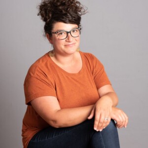Sarina is a white female wearing an orange shirt.