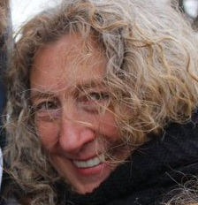 Sandy is a white woman with curly hair.